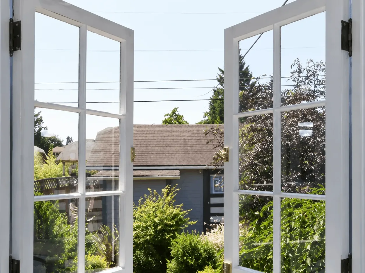 Vinyl casement window opened onto a garden